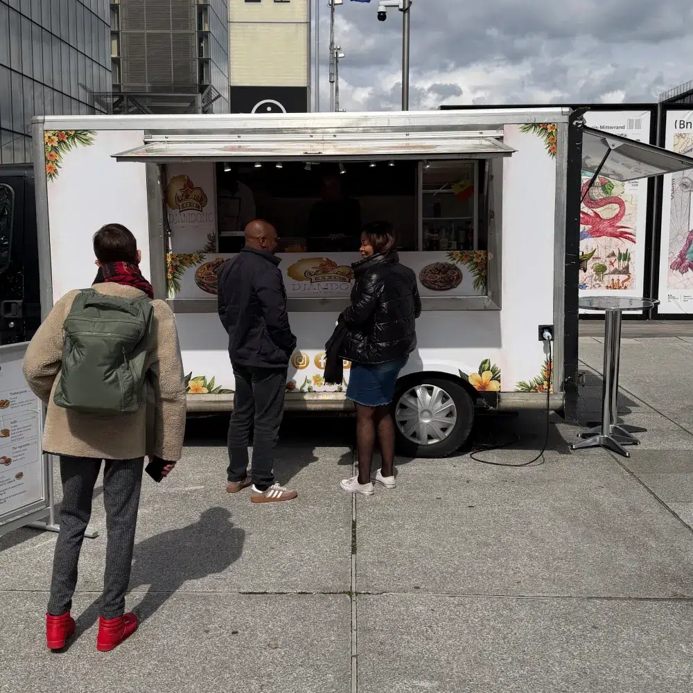 Food truck en plein air | DJAMDONG FOOD Personnes devant un food truck en extérieur.