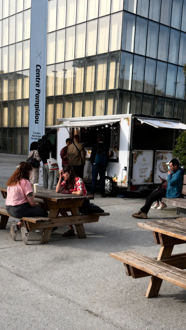 Food truck au Centre Pompidou | DJAMDONG FOOD Personnes assises près d'un food truck au Centre Pompidou.